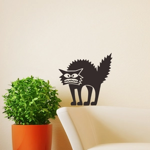 Detailed view of scary cartoon black cat wall decal applied in a cozy living room setting