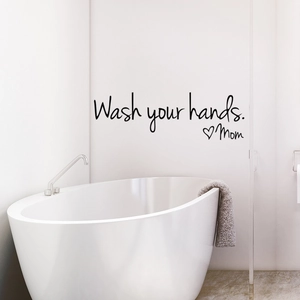 Close-up of Wash Your Hands Mom wall sticker with black script and heart in bathroom