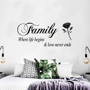 Modern black PVC wall sticker with Family and rose design above a cozy bed frame
