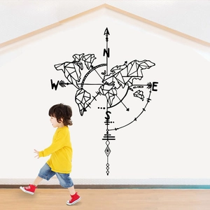 Black geometric world map and compass wall decal applied to a modern living room wall