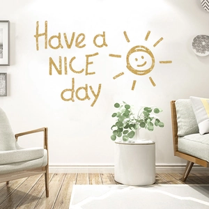 Détail du sticker mural doré Have a NICE day avec un design de soleil minimaliste