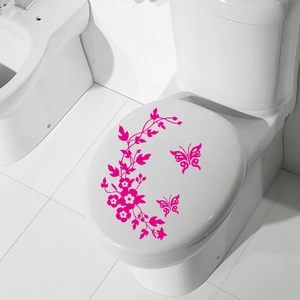 Pink butterfly and floral vine decorative sticker applied to a white toilet lid cover