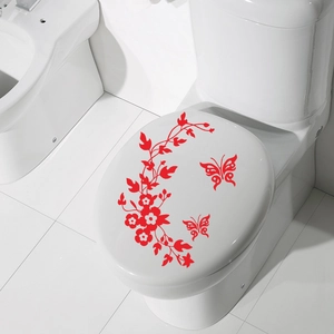 Detail view of red butterfly floral stickers on a white ceramic toilet lid