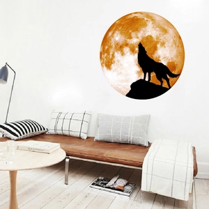 Glow-in-the-dark moon and howling wolf wall decal in orange silhouette for living room