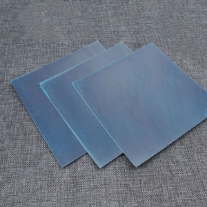 Three square blue acrylic mirror wall stickers displayed on a textured gray background