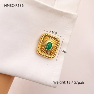 Macro shot of gold stainless steel cufflinks with green stones on a white shirt sleeve