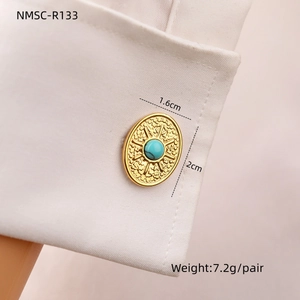 Macro detail of gold cufflinks with turquoise stone and sunburst texture on a white cuff