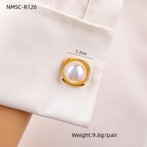 Dettaglio del gemello quadrato in perla da 1,7 cm su un polsino di camicia bianca