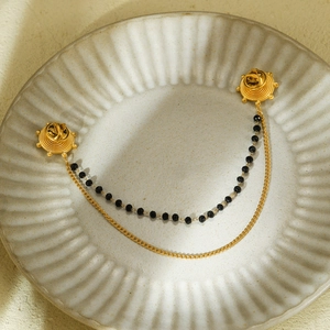 Détail du pin's de col soleil doré avec doubles chaînes et perles noires pour chemise