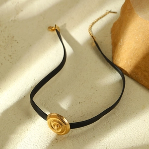 Eleganter schwarzer Leder-Choker mit einem goldenen, spiralförmig gehümmerten Anhänger