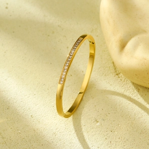 Polished gold stainless steel bangle featuring star-inspired inlaid zircon stones