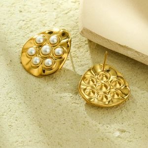 Macro detail of irregular gold finish earrings with center-set pearl flower cluster