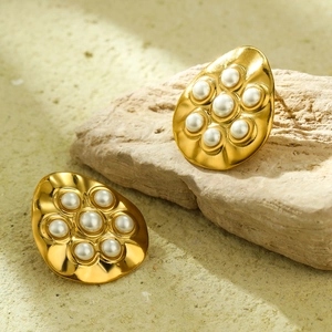 Elegant 18K gold-plated irregular round earrings with white pearls on a natural stone background