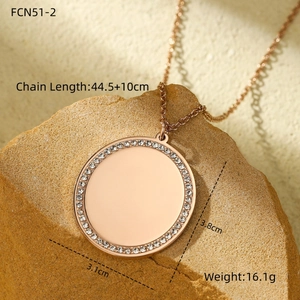 Détail du pendentif rond en or rose serti de strass sur une pierre naturelle
