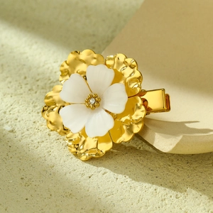 Elegant gold flower hair clip with white petals and a crystal center on stone base