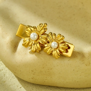 Elegant gold flower hair clip with pearls on stone background, vintage petal hair accessory