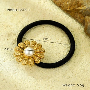 Macro detail of a golden sunflower hair tie with a white pearl on a natural sand background