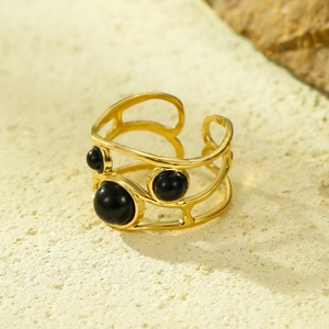 Dettaglio anello in acciaio inossidabile placcato oro 18k con tre pietre nere