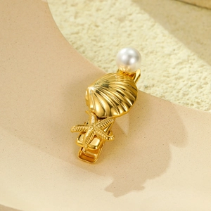 Barrette dorée étoile de mer et coquillage avec perle sur fond texturé élégant