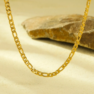 Classic 18K gold plated Figaro chain necklace displayed on a natural rock background