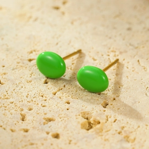 Detail view of oval 18K gold plated stud earrings with bright green enamel finish