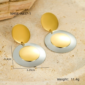 Close-up of mixed metal round earrings on stone tray with 5.4cm and 3.29cm measurements
