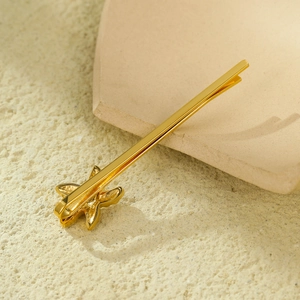Barrette en étoile de mer dorée à l'or 18 carats sur un plateau en pierre texturé