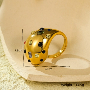 Détail macro d'une bague goutte en acier plaqué or avec des zircons colorés