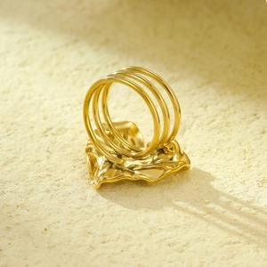 Vista macro dell'anello a cuore dorato con trama a onde ed effetto metallo liquido