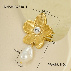 Detailed close-up of golden flower ring featuring a baroque pearl and etched texture