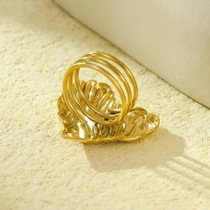 Detail of a gold heart-shaped ring with unique textured surface and triple-band design