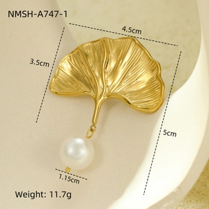 Macro view of golden ginkgo leaf jewelry with pearl detail and ribbed texture