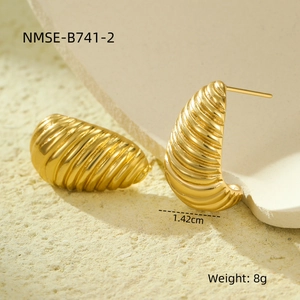 Vista macro de pendientes dorados con textura espiral en forma de capullo y estilo retro