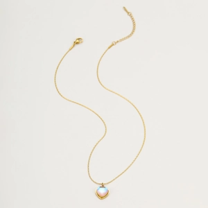 Detail view of heart-shaped moonstone pendant necklace with gold chain and lobster clasp