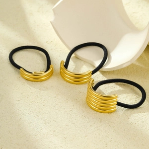 Three-piece set of black elastic hair ties with multi-layered ribbed gold metal accents