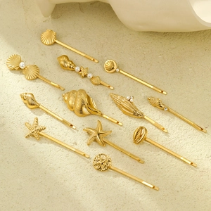 Lot de 11 barrettes dorées thème marin avec étoiles de mer et perles sur fond beige clair