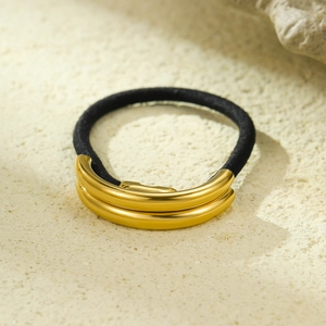Detailed close-up of glossy gold metal buckle on a black elastic ponytail hair tie