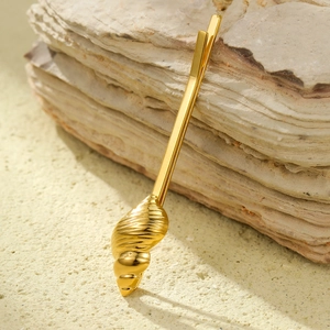 Vue detaillee d'une pince a cheveux en coquillage dore avec texture de spirale marine