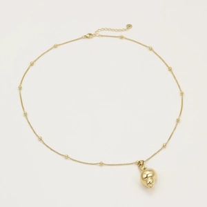 Close-up of golden conch shell pendant on stainless steel chain with lobster clasp