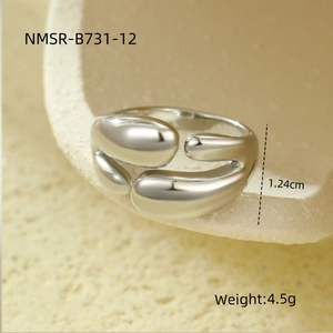 Vue macro d'une bague ouverte en acier inoxydable style métal liquide sur socle