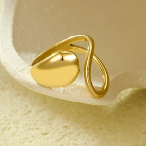 Détail macro d'une bague géométrique irrégulière en acier inoxydable doré sur pierre