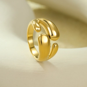 Détail macro d'une bague dorée réglable au design de lave fluide avec finition polie miroir