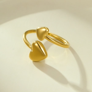 Détail de bague dorée ajustable avec deux coeurs 3D polis dans un style minimaliste épuré