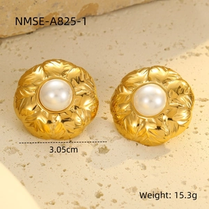 Detalle de pendientes de pétalos en oro 18k con perlas de 3,05cm sobre fondo piedra
