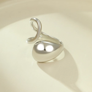 Vue macro d'une bague goutte argentée minimaliste avec finition miroir polie