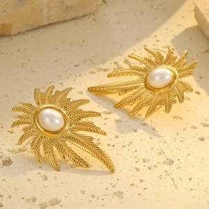 Detalle macro de pendientes de pétalos bañados en oro 18k con perla sobre piedra