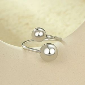 Vue macro d'une bague ouverte en acier inoxydable argenté avec double billes lisses