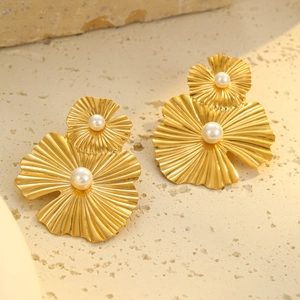 Vista detallada de pendientes de hoja de ginkgo de oro de 18k con perlas sobre una piedra