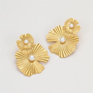 Detalle de pendientes de flores bañados en oro de 18k con perlas y textura de pétalos