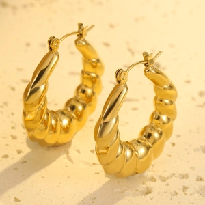 Detail view of 18K gold plated stainless steel hoop earrings with twisted wave texture